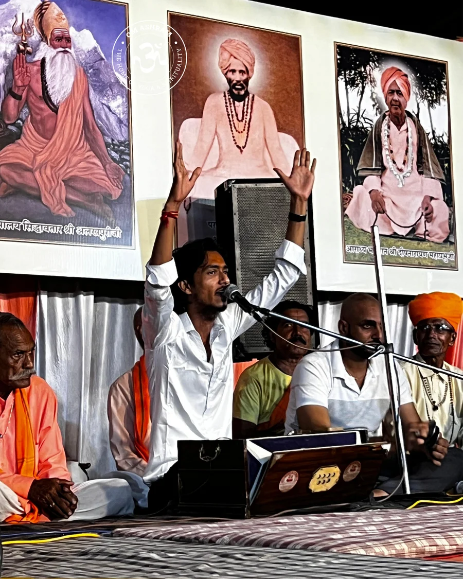 A bhajan singer performing with Shree Devpuriji’s picture in the background.